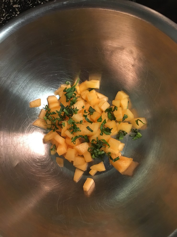 Cantaloupe and thai basil in a bowl.