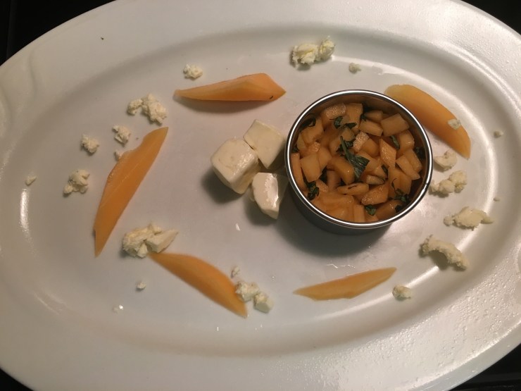 Strips of cantaloupe and feta crumbles scattered on the plate.