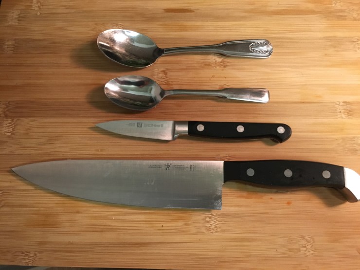 A chef's knife, a paring knife and two spoons.