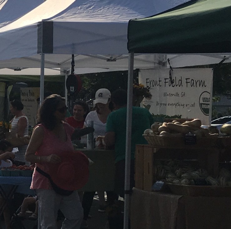 People under tents at a farmer's market.