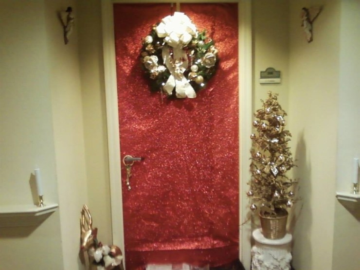 An apartment door with Christmas decorations.
