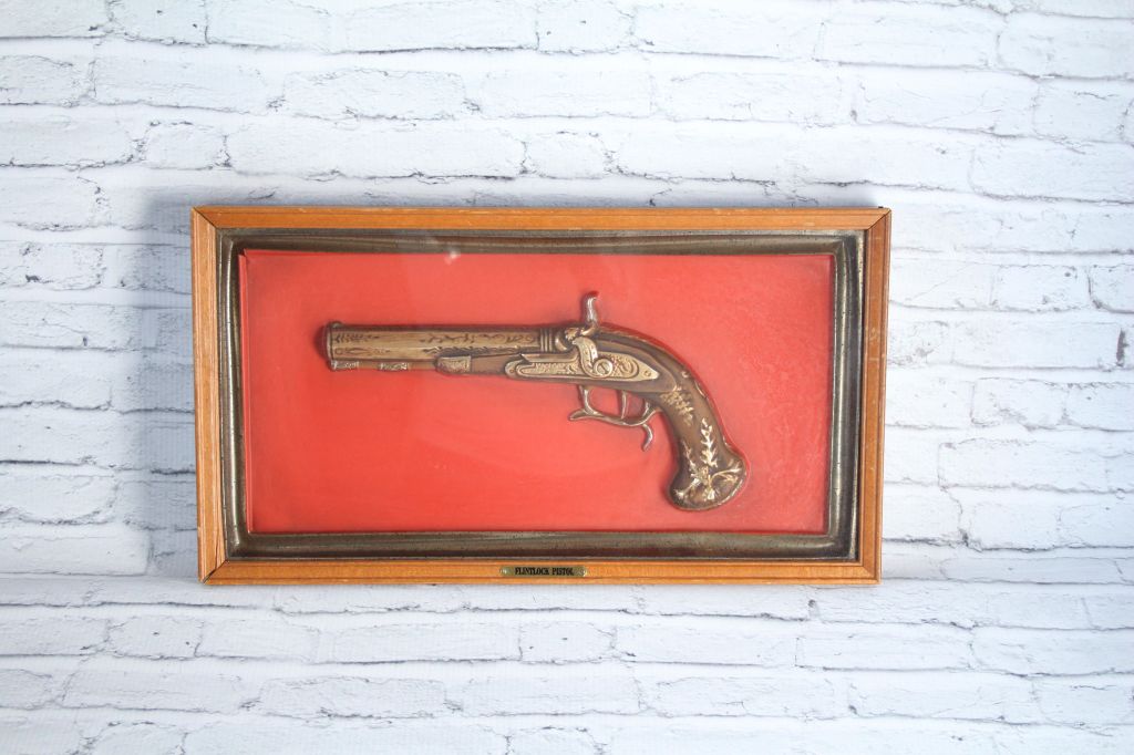A vintage pistol on a wall.