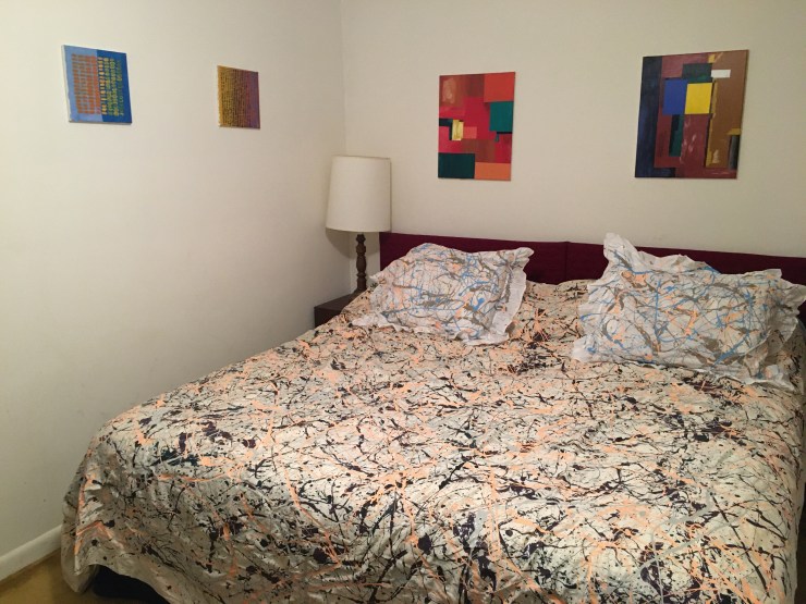 Bedroom filled with abstract art.