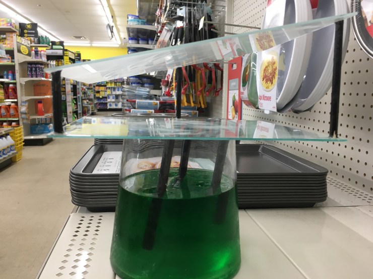 “Cookware Conflict”: glass and wood mounted on jello filled vase.