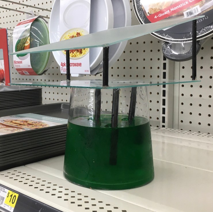 “Cookware Conflict”: glass and wood mounted on jello filled vase.