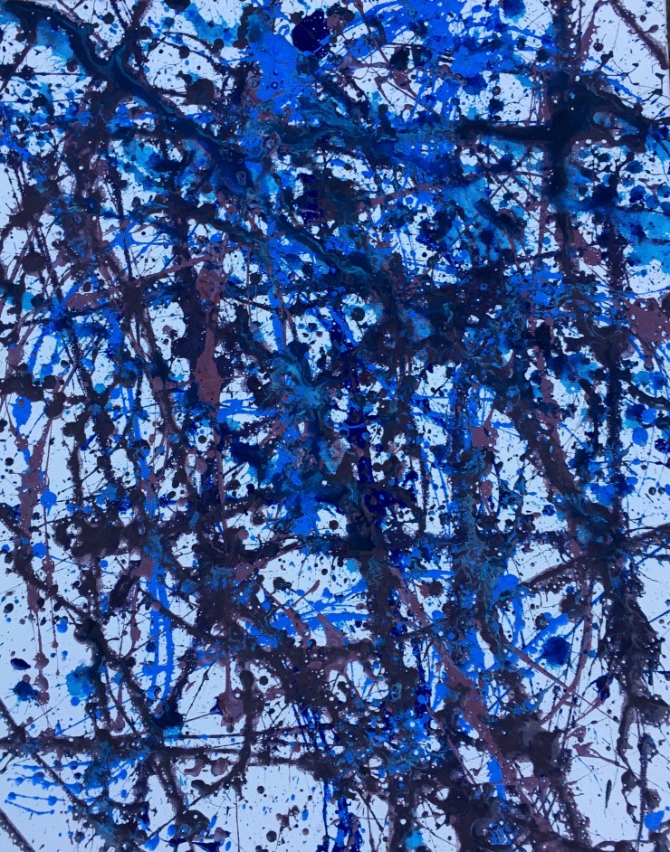 Various shades of blue splattered on a canvas with a toothbrush.