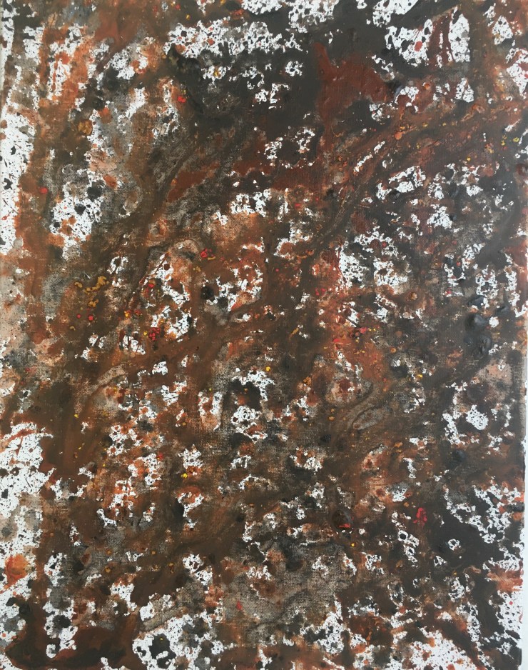 Black, brown and orange splatters on a canvas.