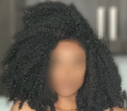 The artist MVT with her face blurred.