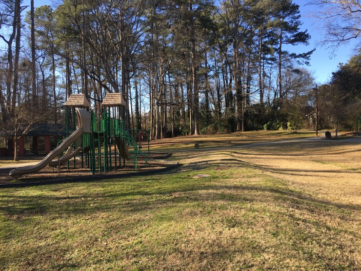 A park with a swing set on the left.