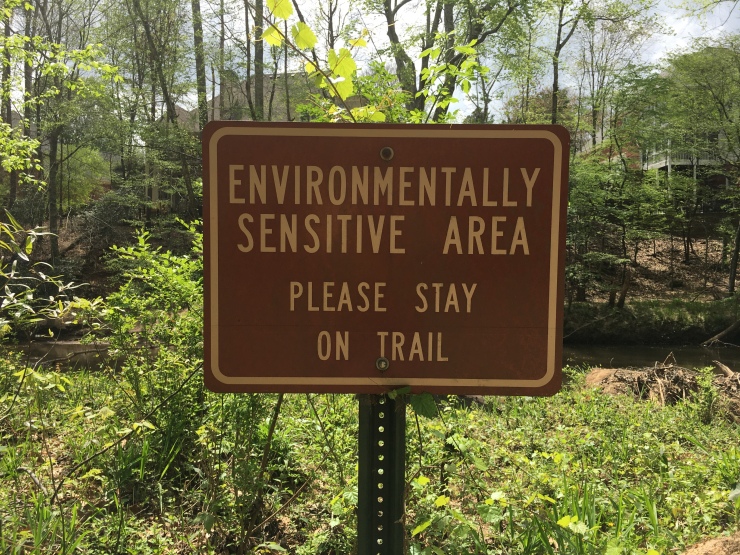 A sign telling people to stay on the trail.