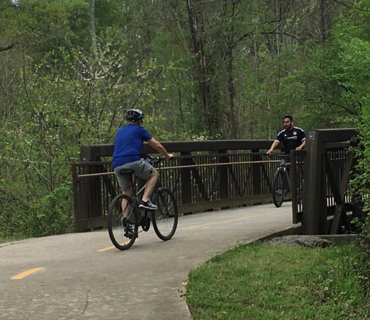Two cyclists crossing a bridge.