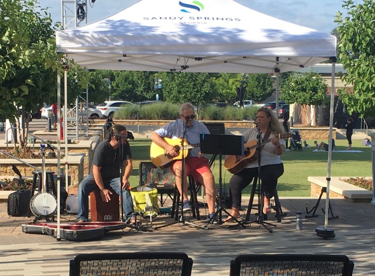 Guitarists and a singer playing live at the farmers market.