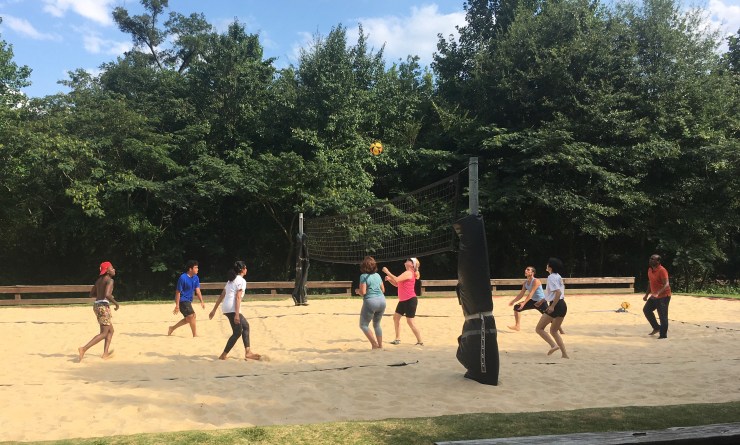Beach volleyball players getting ready to hit the ball.