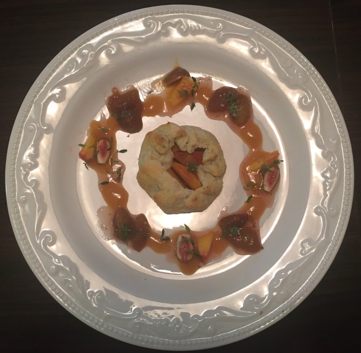 Birds eye view of peach galette and fig compote on a white plate.