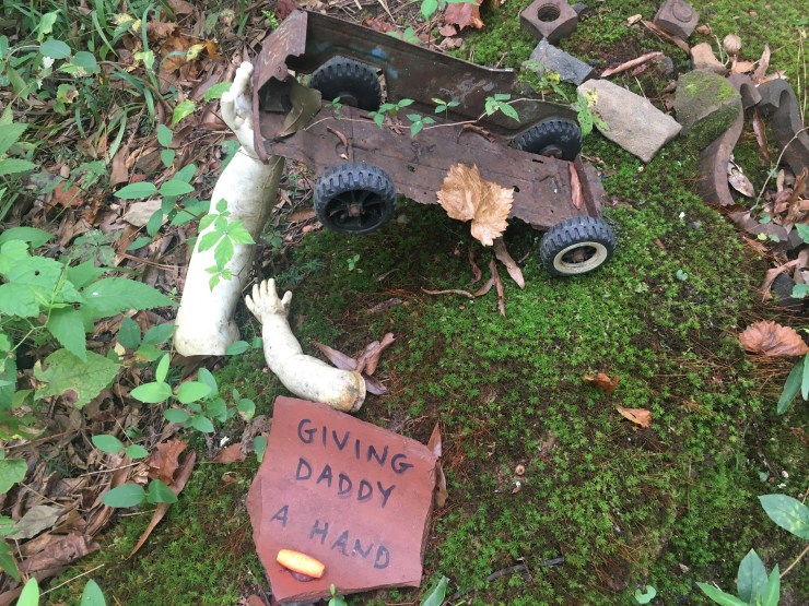 Doll’s arm holding up a toy truck.