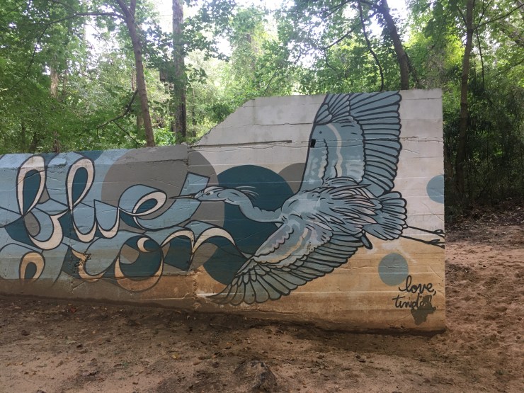 Mural of blue heron on a retaining wall.