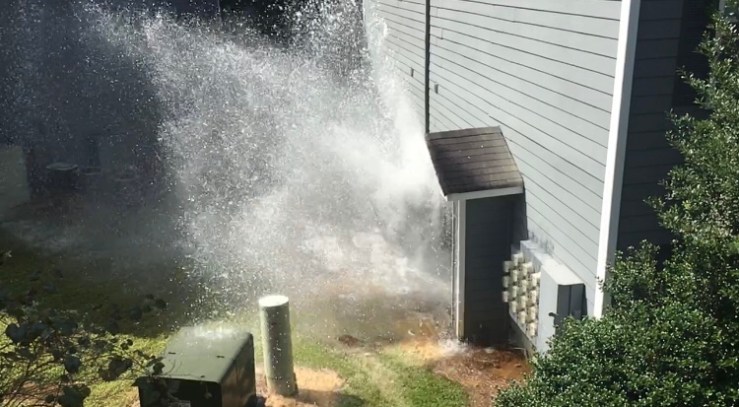 Water gushing from a utility shed.