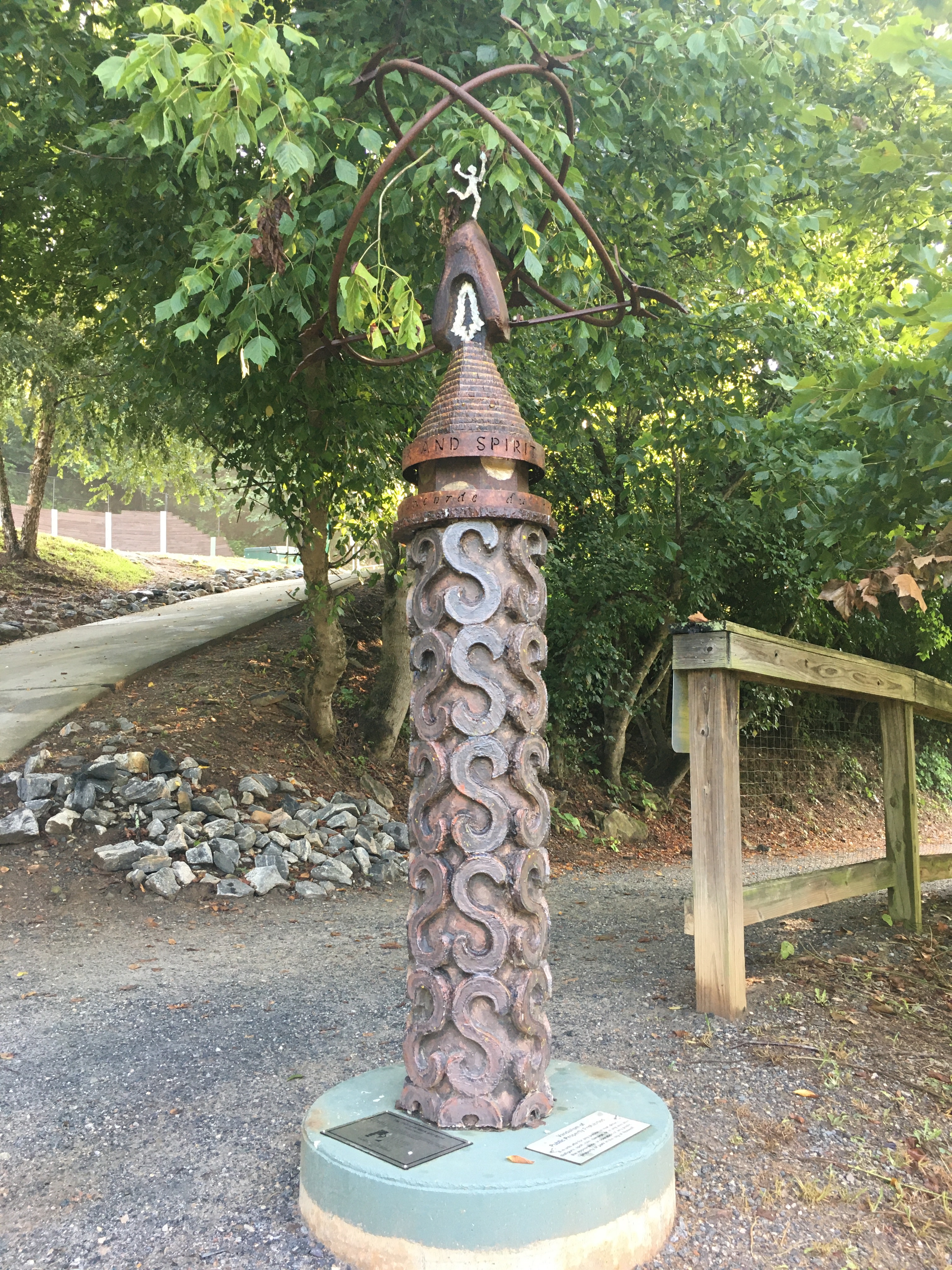 Cylindrical statue on a hiking trail.