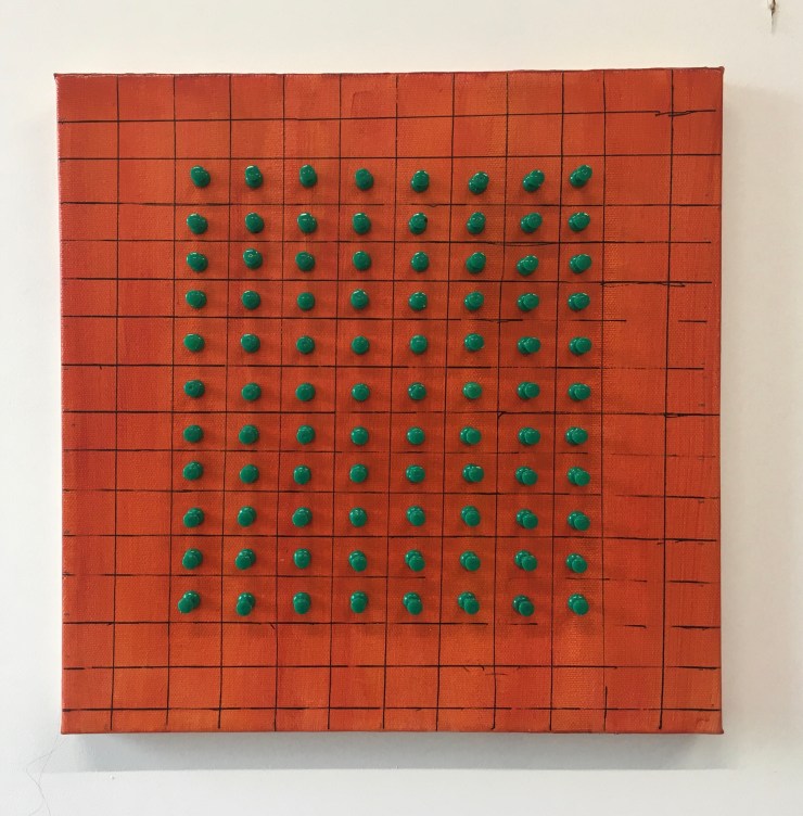 Green push pins on an orange canvas.
