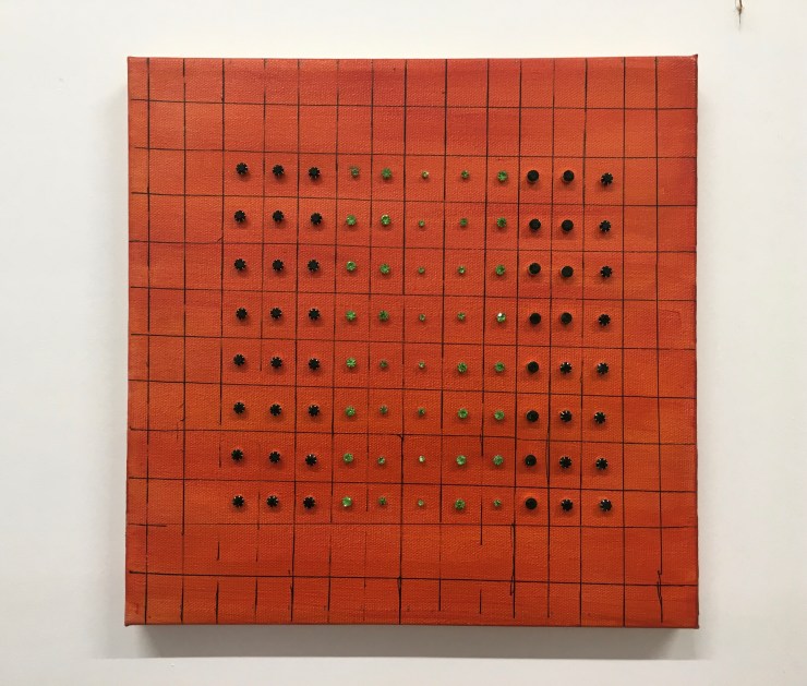 Green earrings on an orange canvas.