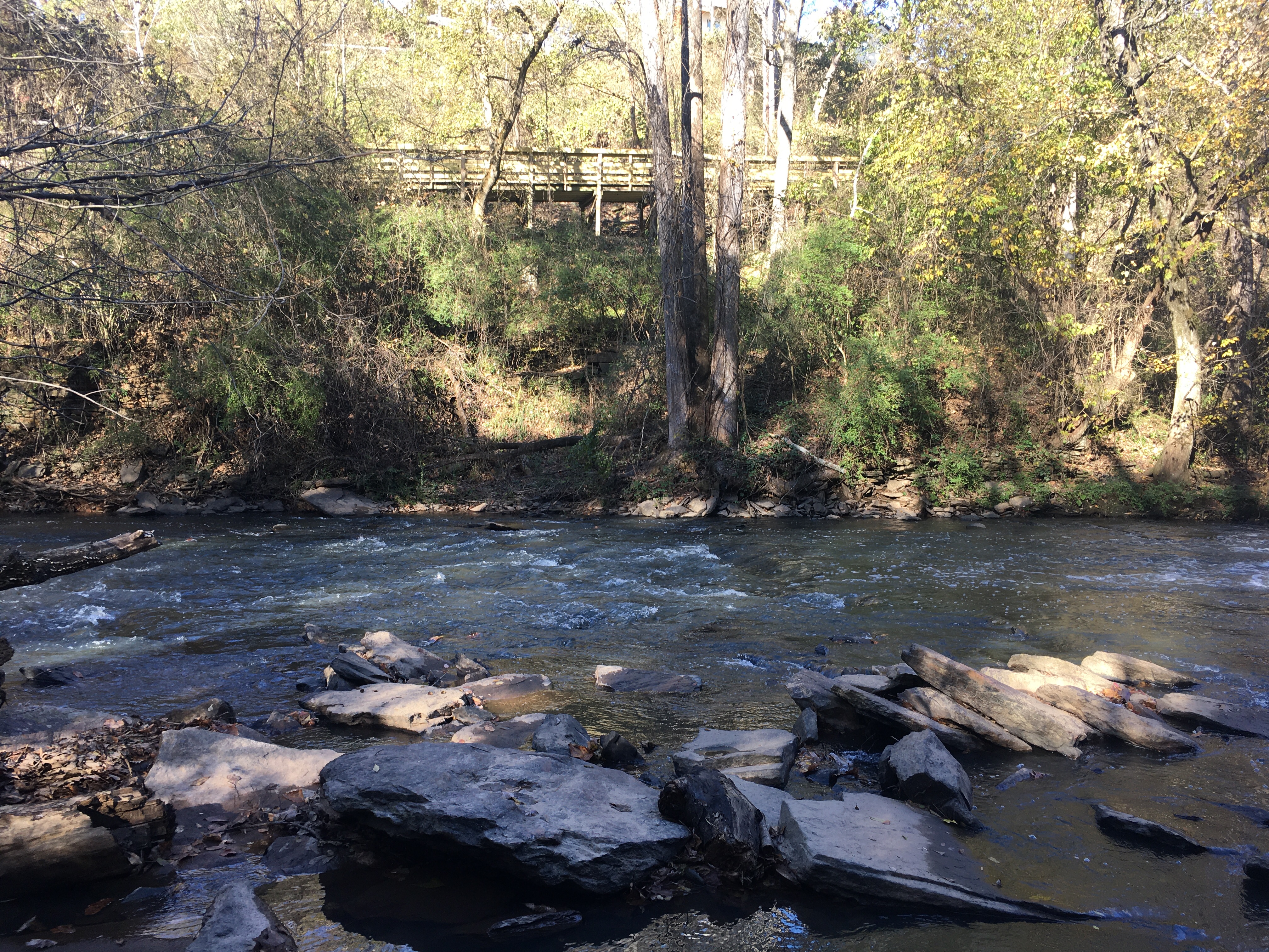River flowing past a wooden bridge.