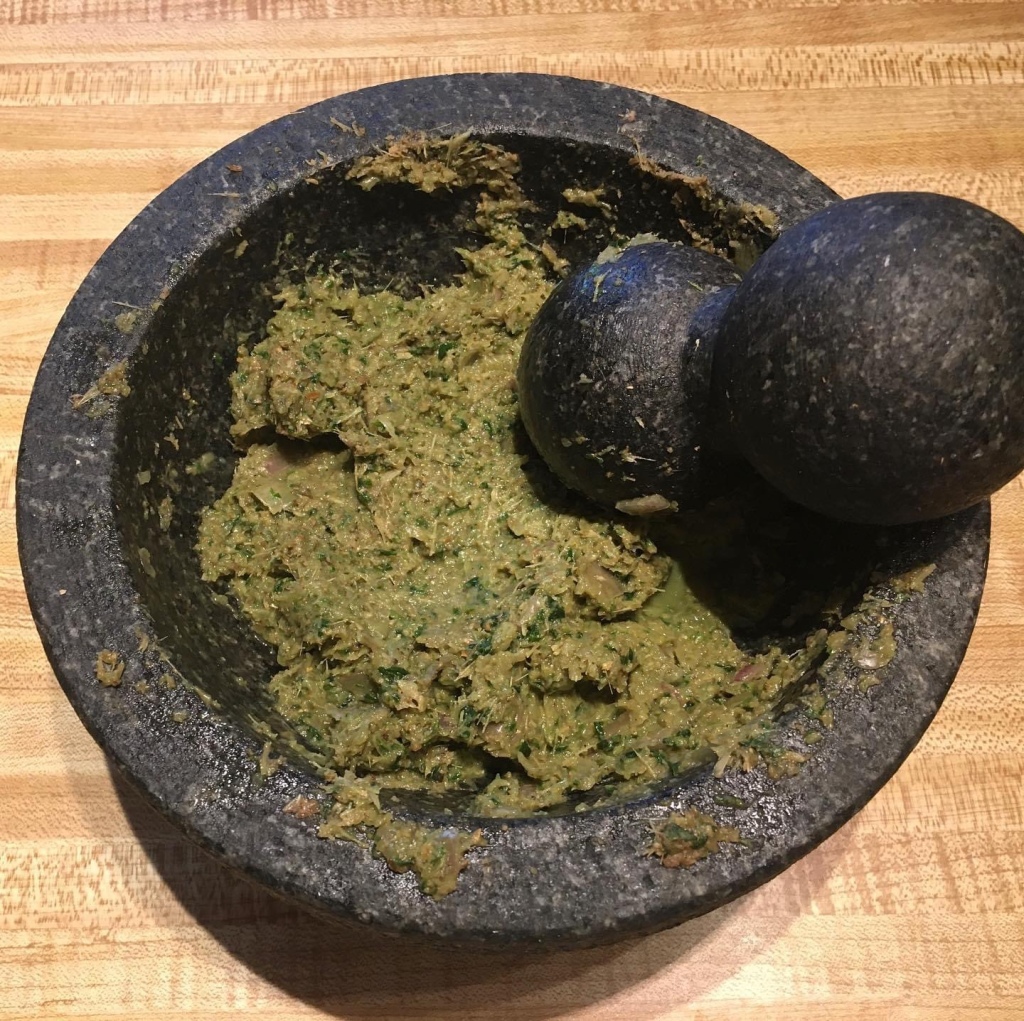 Green curry paste in a mortar and pestle.