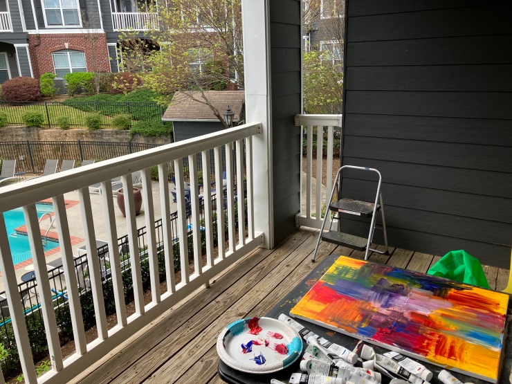 Art materials on table that is on a patio.