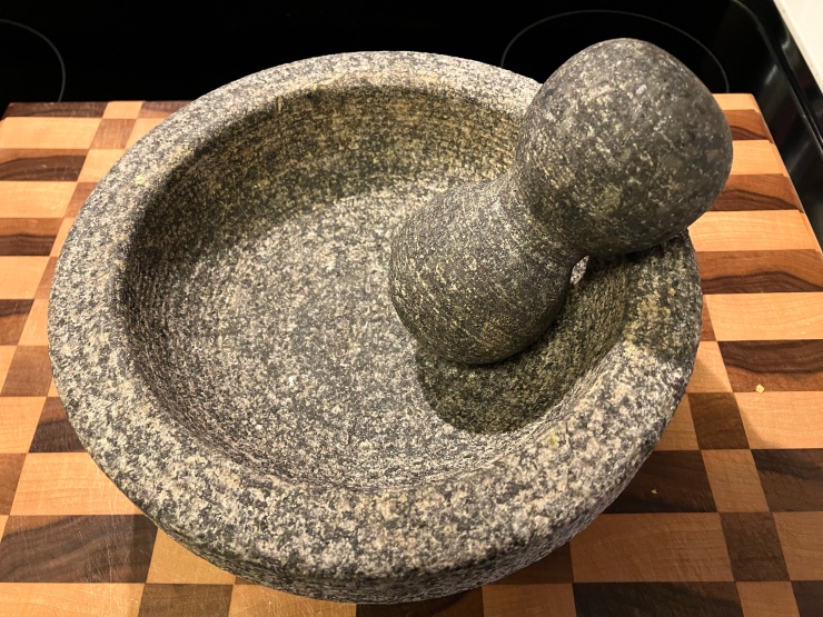 Mortar and pestle on a cutting board.