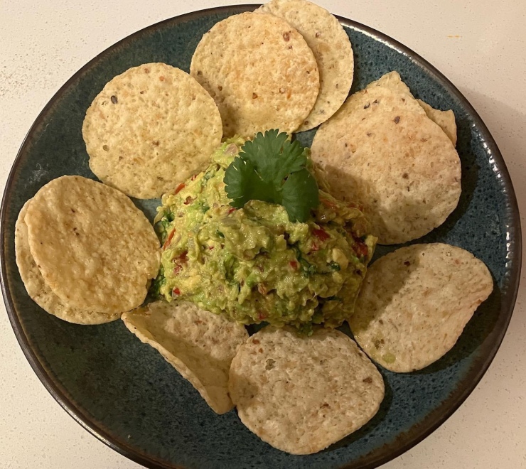 Chips and guacamole in a shallow bowl.
